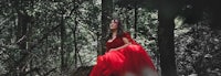 a woman in a red dress in the woods